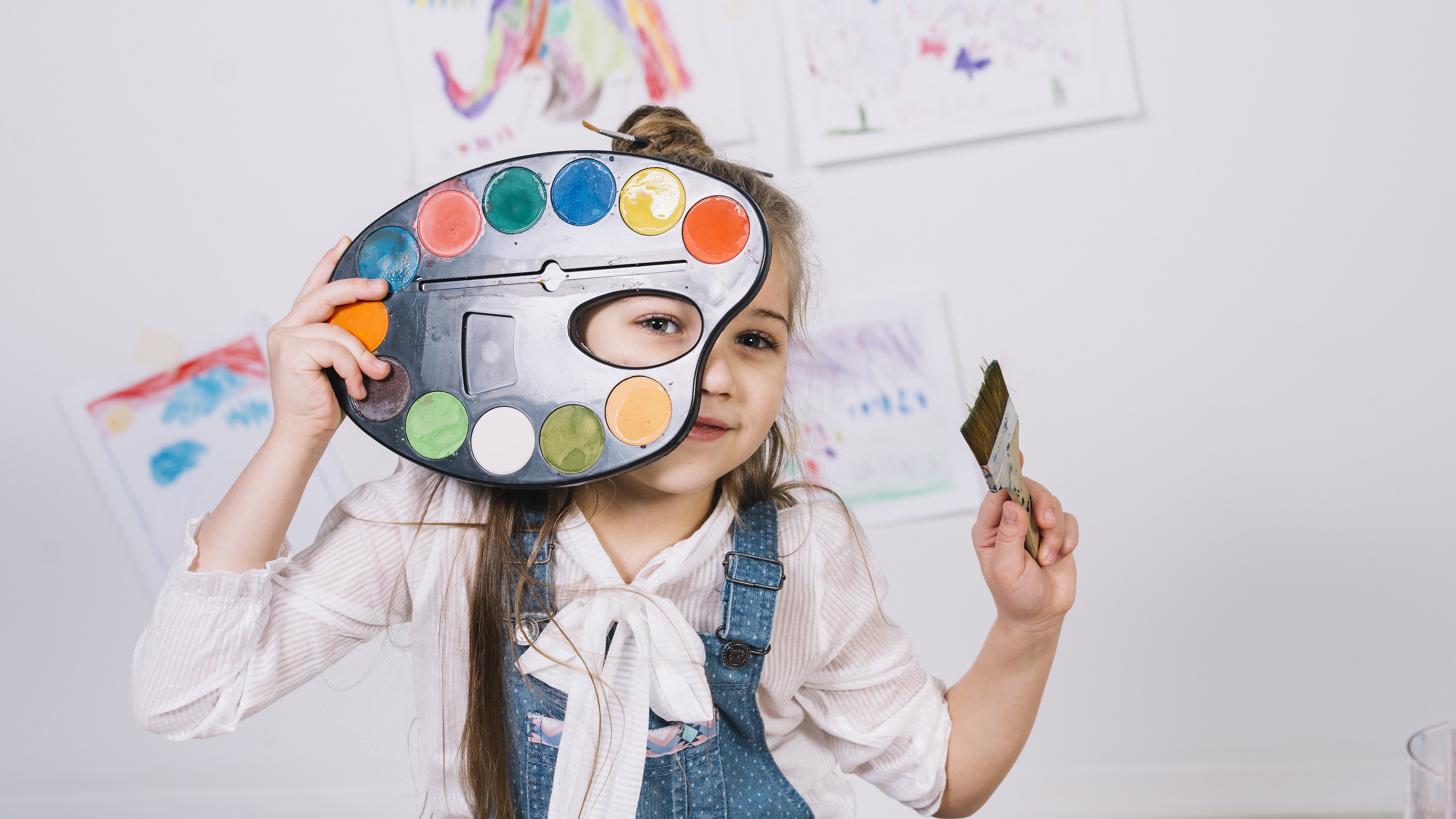 Girl holding paintbrush doing arts