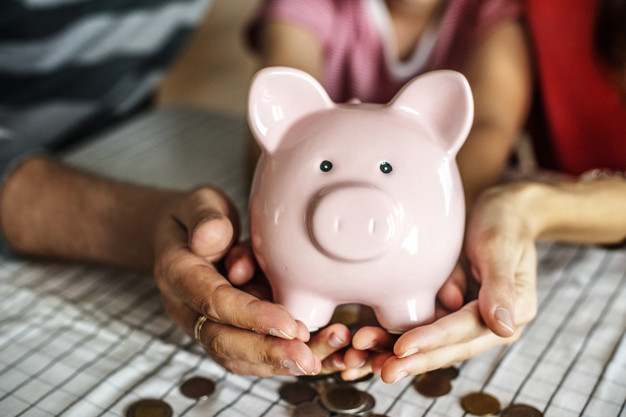 man and woman holding a piggybank