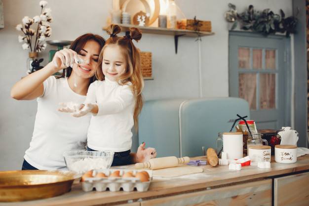 girl preparing meal with mom