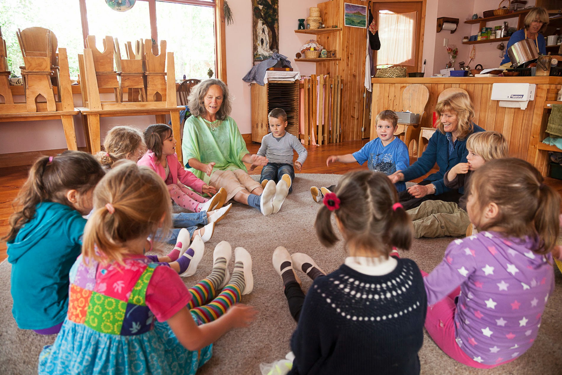 Preschool teacher with students in a circle 
