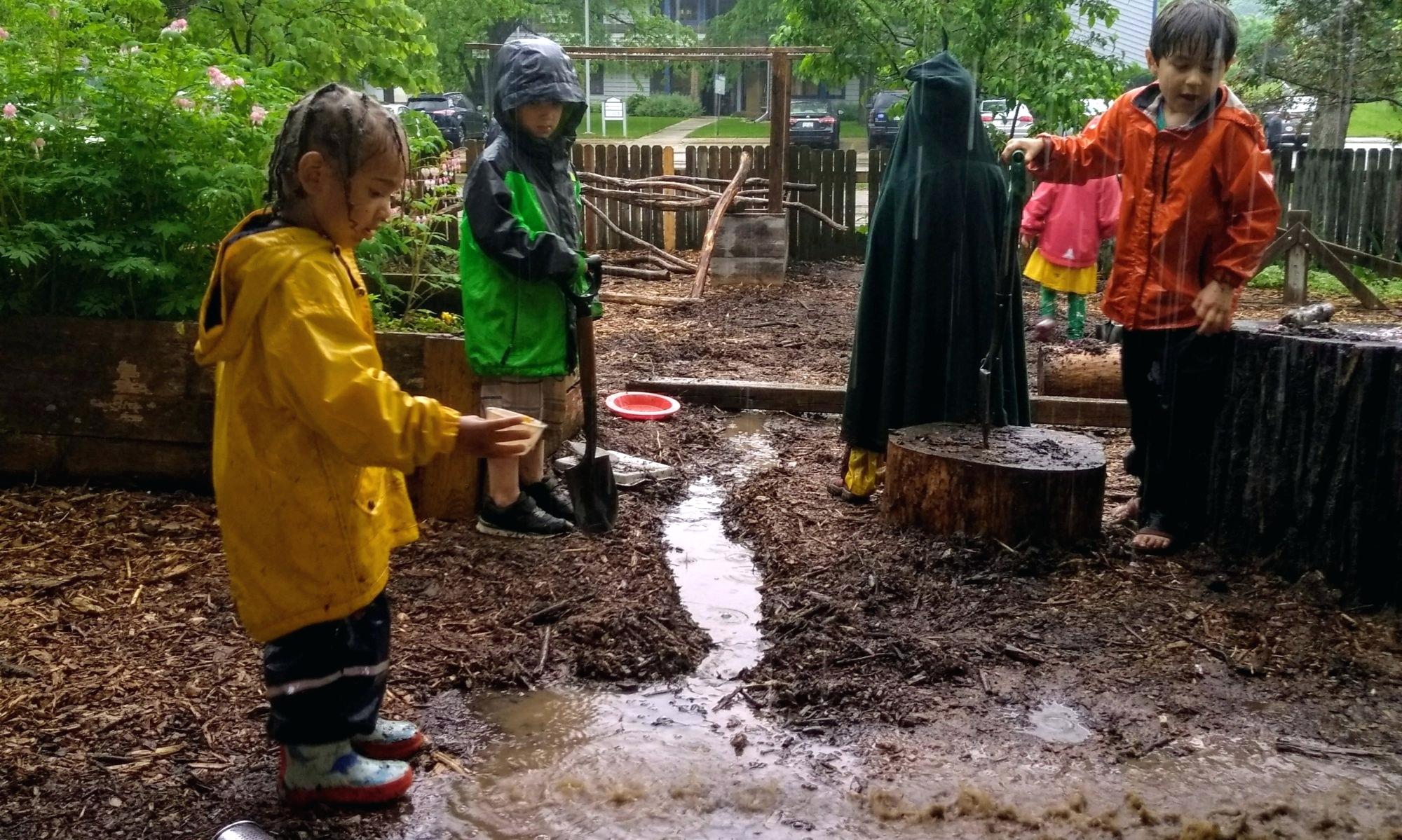 Kids having messy play at the garden during rain time