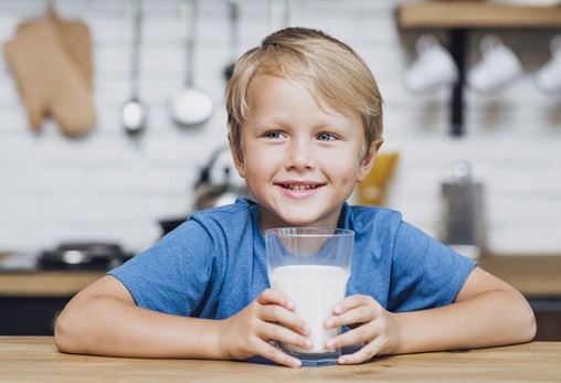 budak lelaki memegang segelas susu