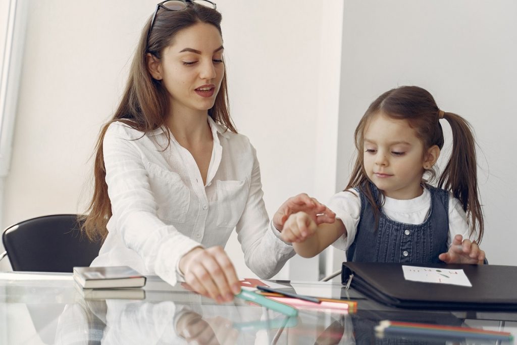 Tutor with pupil. Little girl studying. Private lesson.