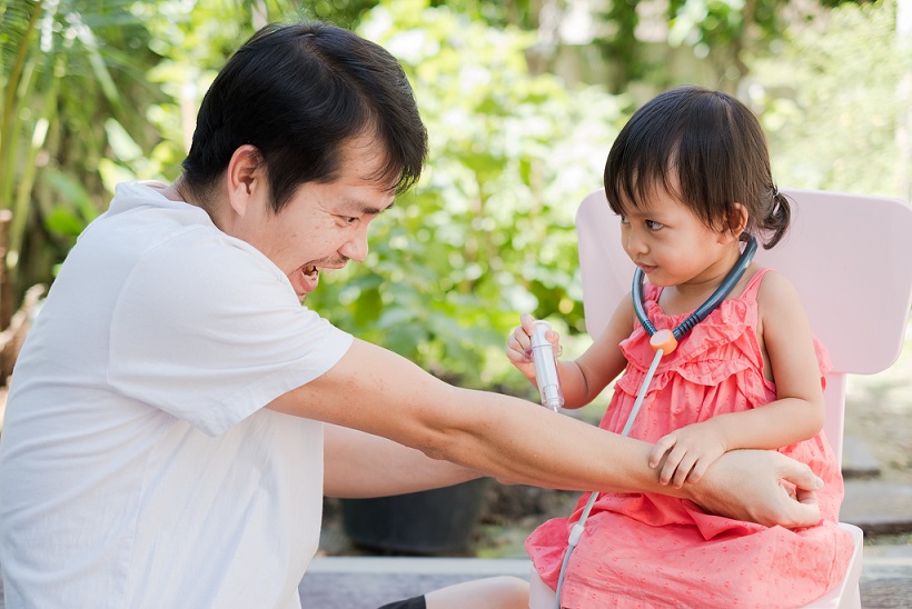 girl role-playing as doctor with father