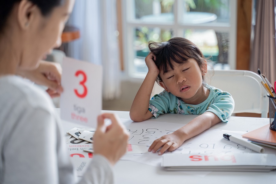 tired and bored toddler while studying with mother at home