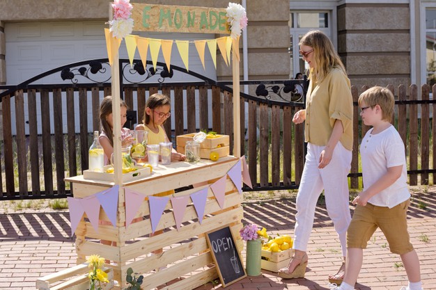 children at a lemonade stand selling and buying